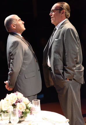 The two men in gray suits, Johnson significantly taller than Russell has his hands in his pocket, Russell looking up at him with his hands clasped behind his back.