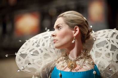 Profile of Portia in blue gown and dragonfly collar.