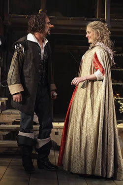 Prouction shot of Cyrano talking with Roxanne, who is wearing a long overcoat