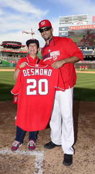 Sarah standing next to Ian Desmond holding his jersey at home plate of Nationals Park