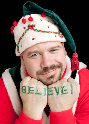 Rick Blunt in elf costum, fists to chin with "Believe" tatooed in green on his knuckles