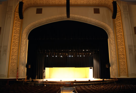 Brooklyn Tech High School auditorium with a light glowing from the back of the stage