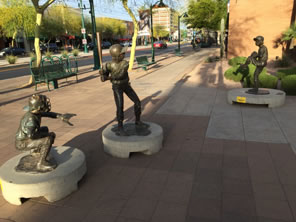 Photo of three statues of children playing baseball