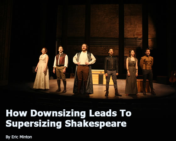 The six Fiasco players in a spotlight and wearing old-style gowns, britches, vests and coats lined up and singing, with the trunk in the background. "How Downsizing Leads To Supersizing Shakespeare by Eric Minton"