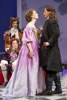 Celimene in a purple French classic dress with gold front stands face to face with Frank in black long-coat suit as two suitors in frilly, multicolored French classic courtier's suits an large, curly wigs watch in the background