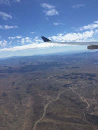 Photo through airline window of desert landscape