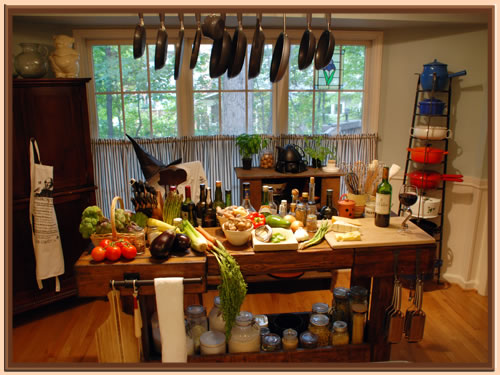 Photo of kitchen with prep table covered in vegetables, cheese, Talbot wine, and a witch's hat in the background