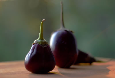 Eggplants standing up on outdoor table with deep focus creating a blurry depth